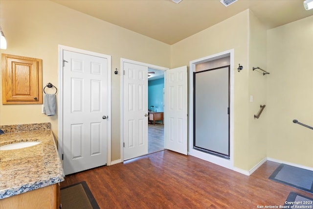 bathroom with vanity, hardwood / wood-style flooring, and a shower with shower door