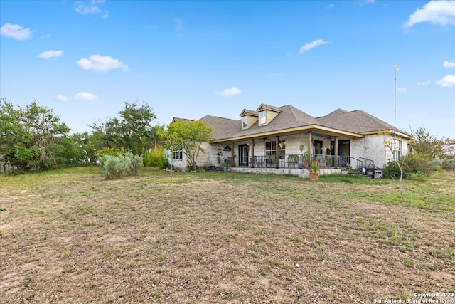 rear view of property featuring a lawn