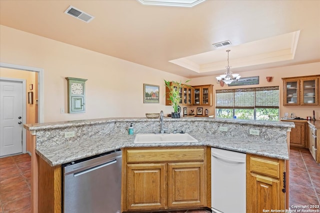 kitchen featuring sink, dishwasher, a raised ceiling, white dishwasher, and an inviting chandelier