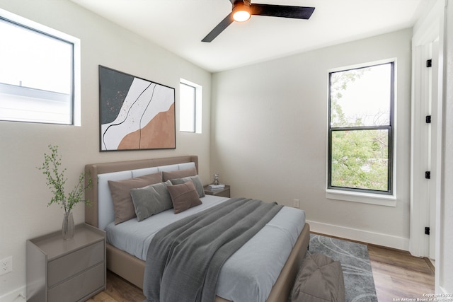 bedroom with ceiling fan and multiple windows