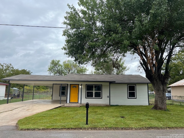 ranch-style house featuring a carport and a front lawn