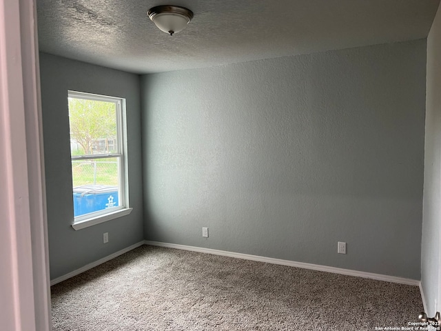 carpeted spare room featuring a textured ceiling