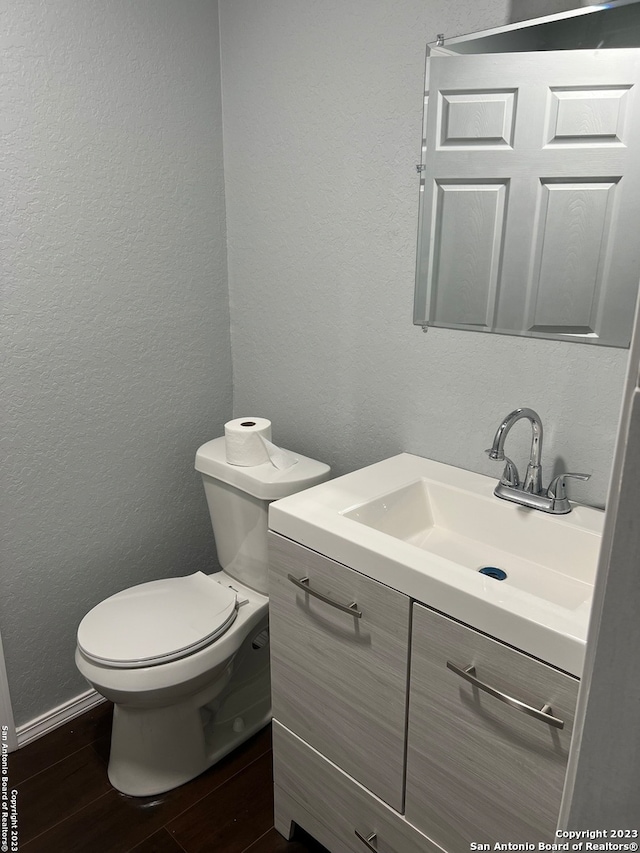 bathroom featuring vanity, wood-type flooring, and toilet