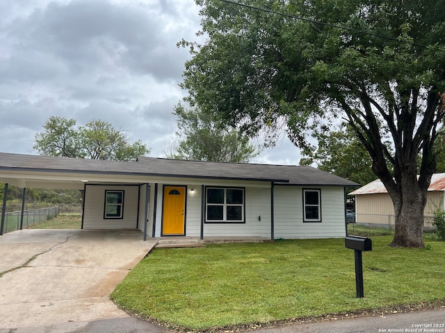 ranch-style home featuring a carport and a front lawn