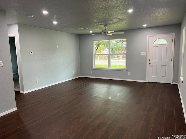 interior space with ceiling fan, a textured ceiling, and dark hardwood / wood-style flooring