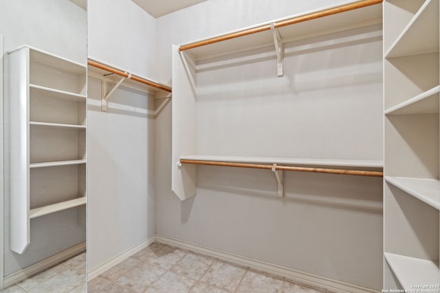 spacious closet with light tile floors