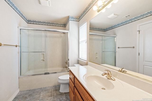 full bathroom with vanity with extensive cabinet space, enclosed tub / shower combo, toilet, and tile floors