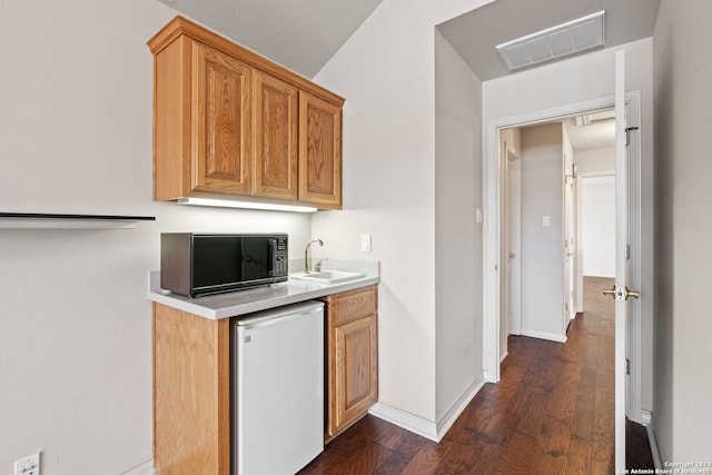 kitchen featuring sink, dark hardwood / wood-style flooring, and white dishwasher