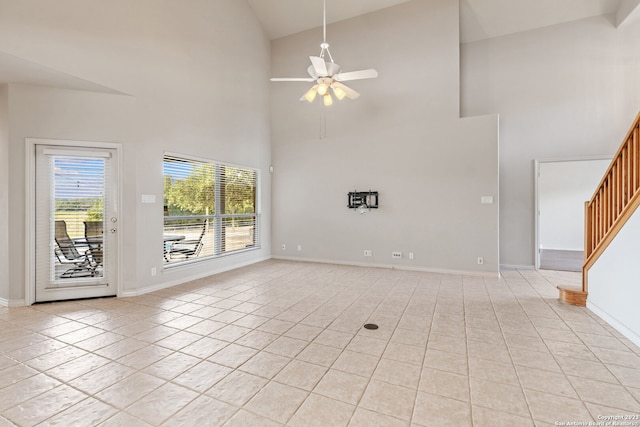 unfurnished living room featuring high vaulted ceiling, ceiling fan, and light tile floors