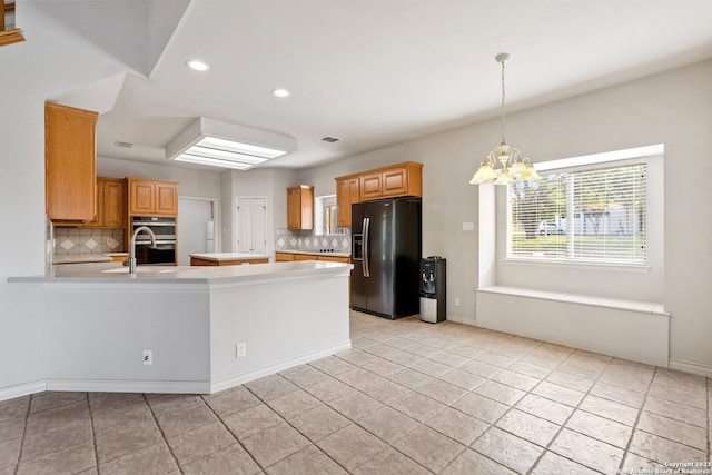 kitchen with double oven, light tile floors, refrigerator with ice dispenser, tasteful backsplash, and an inviting chandelier