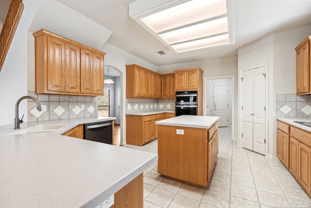 kitchen featuring double oven, a kitchen island, sink, tasteful backsplash, and dishwashing machine