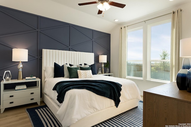 bedroom featuring hardwood / wood-style flooring, vaulted ceiling, and ceiling fan