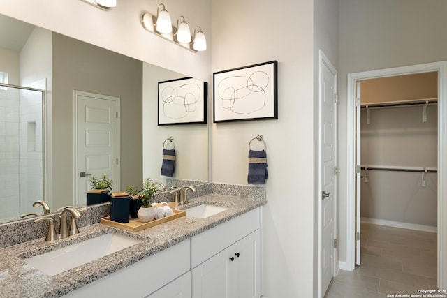 bathroom with tile patterned flooring, vanity, and a shower with shower door