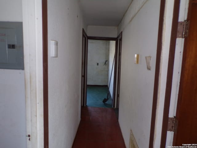 hall featuring dark tile floors