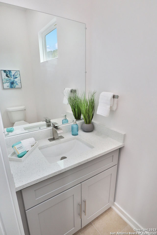 bathroom with tile floors, toilet, and vanity