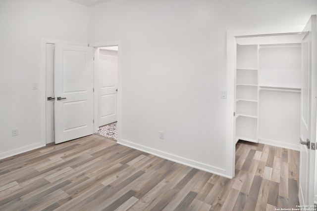 unfurnished bedroom with hardwood / wood-style floors and a closet