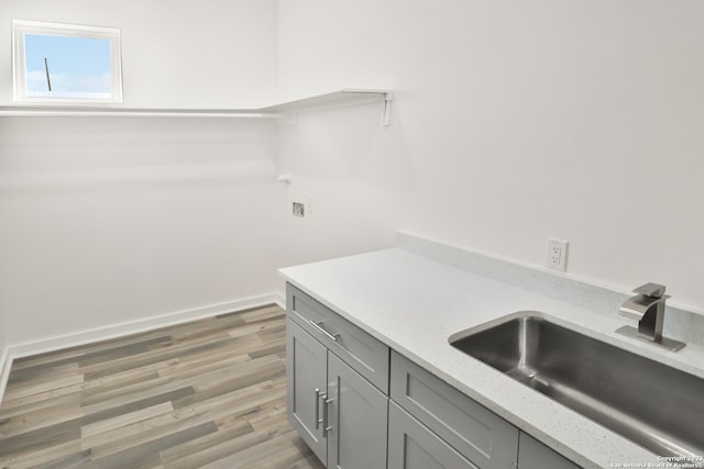 washroom with light hardwood / wood-style floors and sink