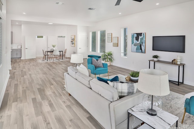 living room featuring ceiling fan and light hardwood / wood-style flooring