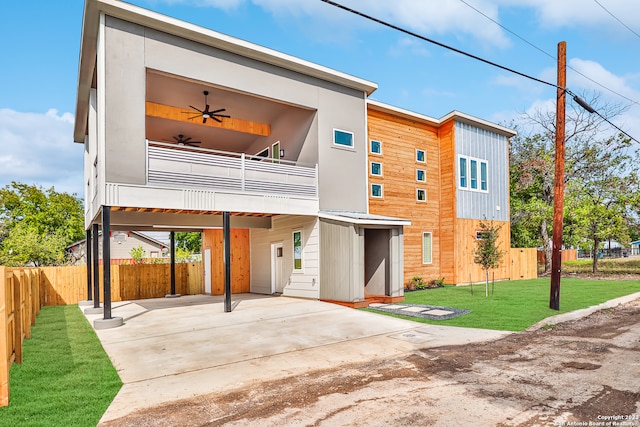 view of front facade with a balcony, a front lawn, and a patio