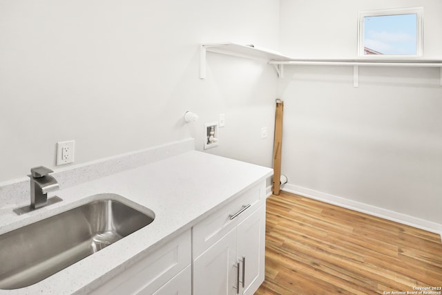 washroom with washer hookup, cabinets, light hardwood / wood-style floors, and sink