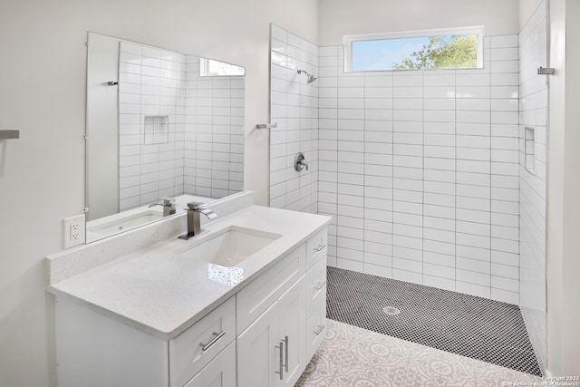 bathroom with vanity and a tile shower