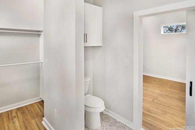 bathroom with hardwood / wood-style floors and toilet