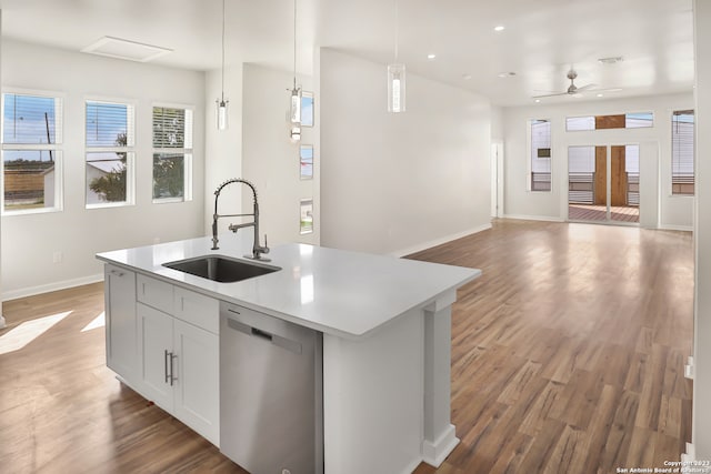 kitchen featuring pendant lighting, ceiling fan, dishwasher, sink, and dark hardwood / wood-style floors