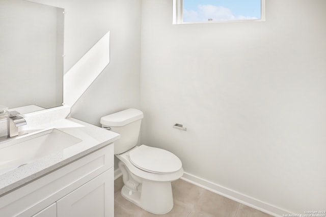 bathroom with tile flooring, toilet, and vanity