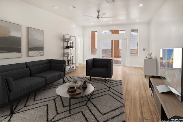 living room featuring plenty of natural light, ceiling fan, and light hardwood / wood-style flooring