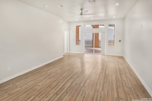 empty room with ceiling fan and light hardwood / wood-style flooring