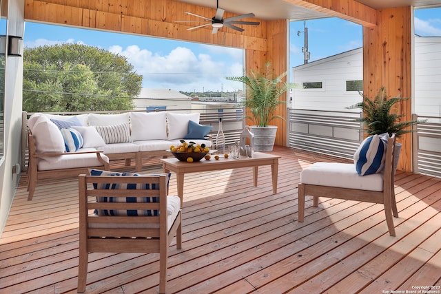 wooden deck featuring outdoor lounge area and ceiling fan