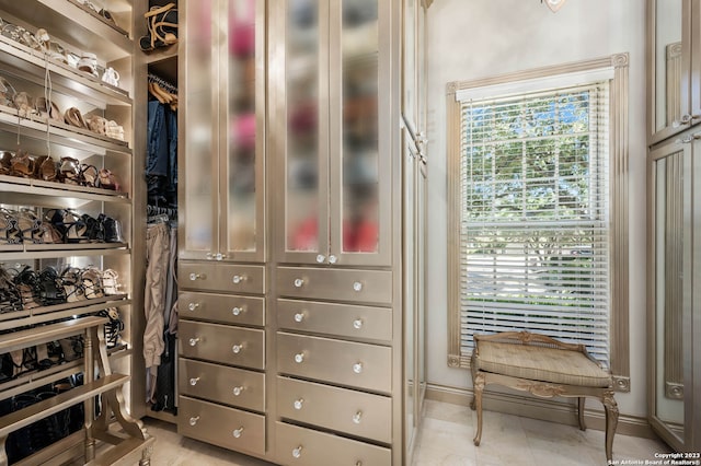 walk in closet with light tile floors