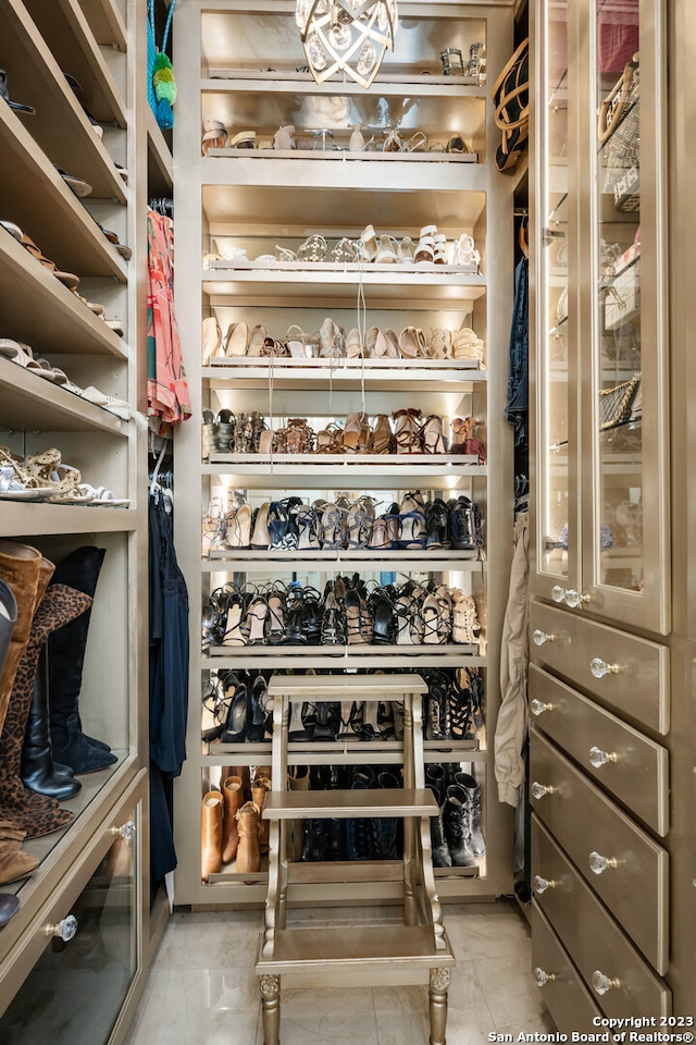 walk in closet with light tile flooring