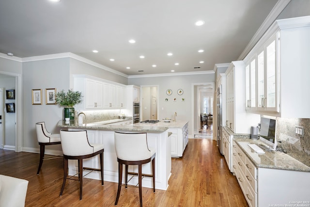 kitchen featuring white cabinetry, light hardwood / wood-style flooring, and tasteful backsplash