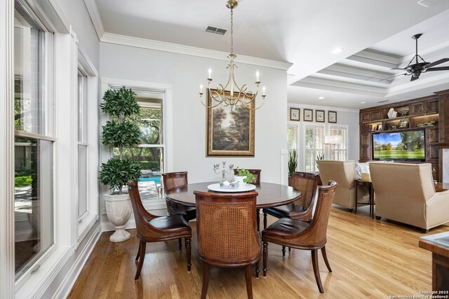 dining area featuring ornamental molding, ceiling fan with notable chandelier, a wealth of natural light, and light wood-type flooring