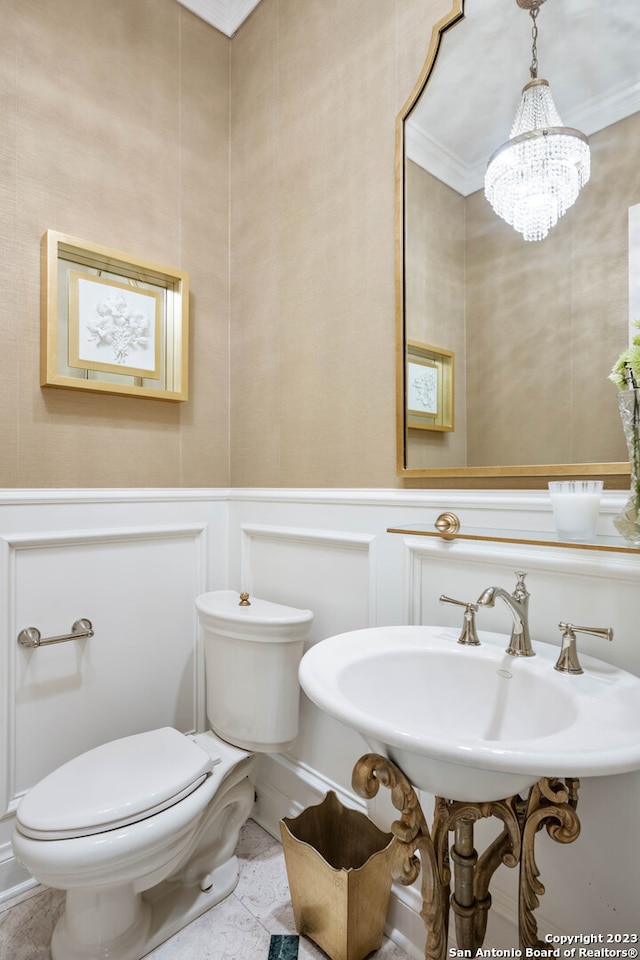 bathroom with toilet, a notable chandelier, crown molding, tile floors, and sink