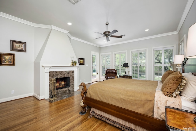 bedroom with crown molding, light wood-type flooring, and multiple windows