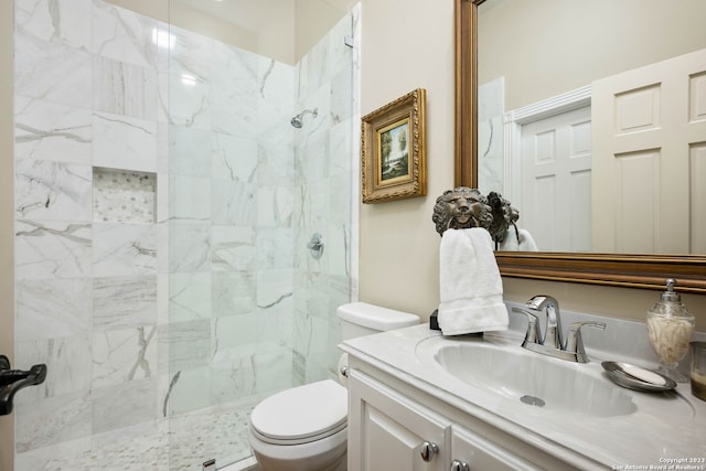 bathroom featuring toilet, a shower with shower door, and vanity