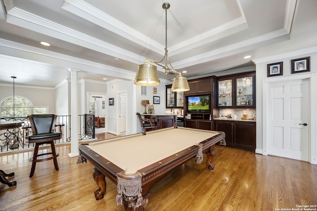 recreation room with billiards, light hardwood / wood-style floors, crown molding, decorative columns, and a raised ceiling