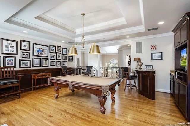 rec room with billiards, ornamental molding, light wood-type flooring, and a tray ceiling