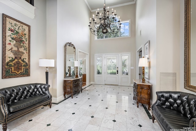 tiled entrance foyer with crown molding, a chandelier, and a towering ceiling