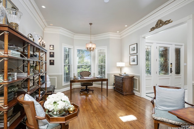 home office with ornamental molding, a notable chandelier, and light wood-type flooring