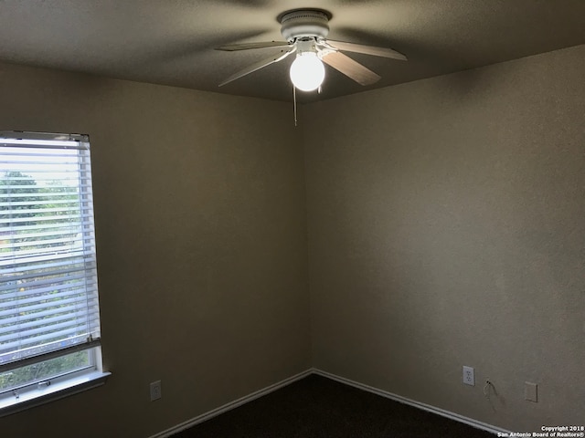 spare room with ceiling fan and carpet