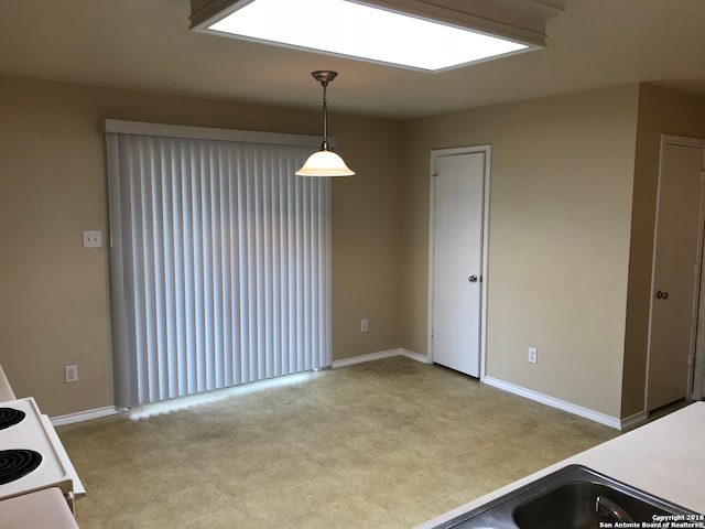 kitchen featuring light tile flooring, decorative light fixtures, and range