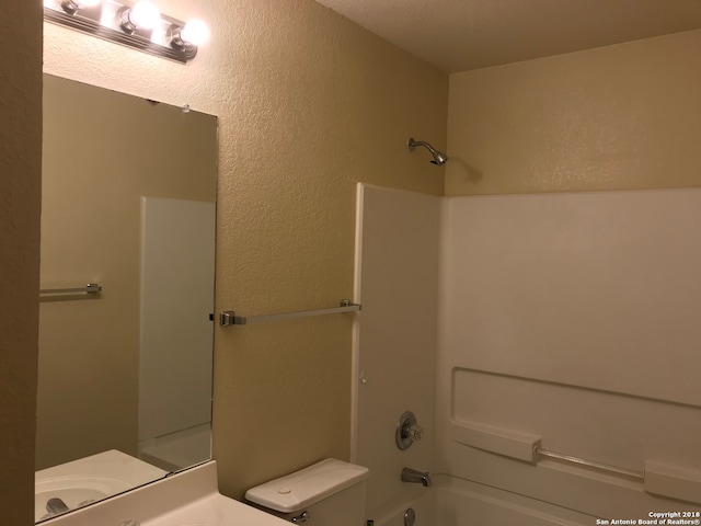 full bathroom featuring vanity, a textured ceiling, toilet, and shower / bath combination