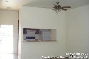 interior space featuring extractor fan, ceiling fan, range, and fridge