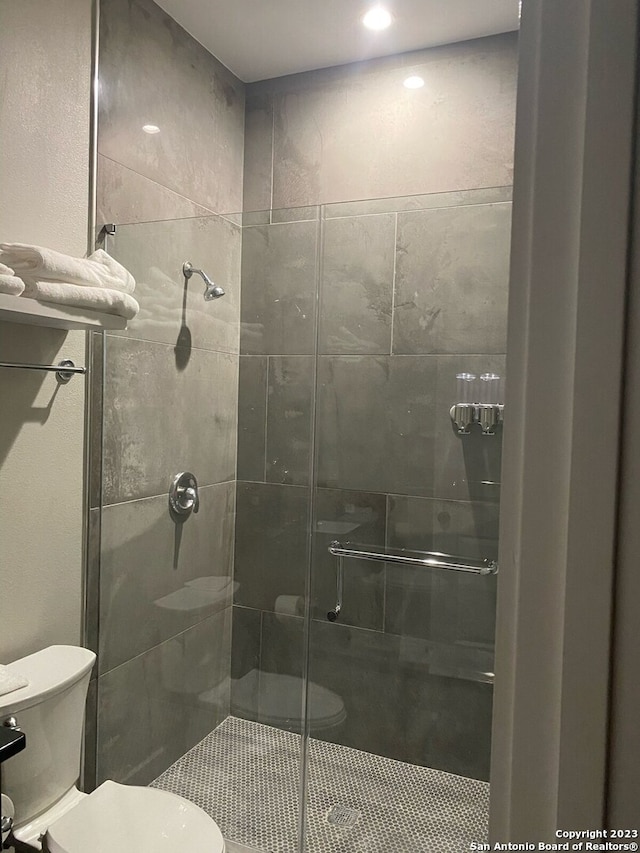 bathroom with toilet and a shower with shower door