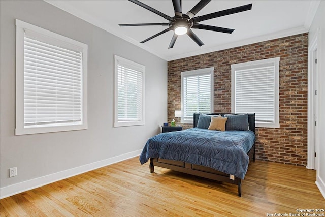 bedroom with ceiling fan, brick wall, crown molding, and hardwood / wood-style floors