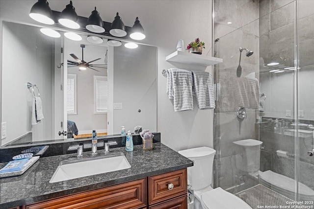 bathroom with ceiling fan, toilet, a shower with door, and vanity