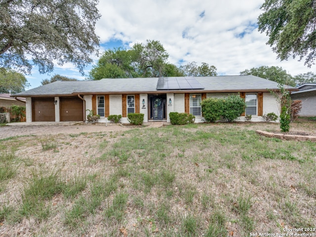 ranch-style house with solar panels and a garage